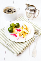Breakfast with fried cutted egg, black coffee and vegetables