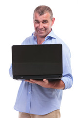 casual middle aged man holding his laptop