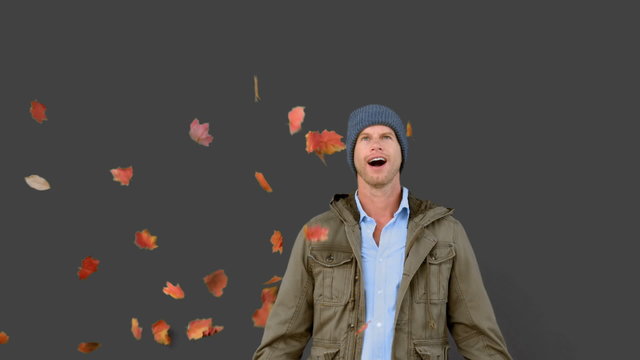 Amazed man looking at falling leaves on grey screen