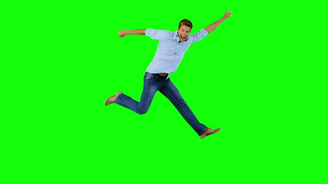 Man jumping and gesturing on green screen
