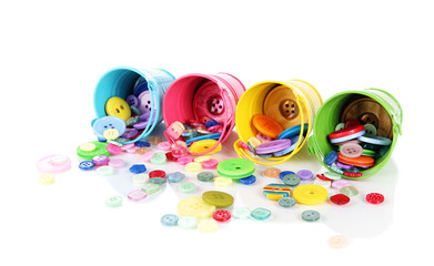 Colorful buttons strewn from buckets isolated on white