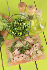 Chicken meat in glass plate,herbs and spices on wooden table