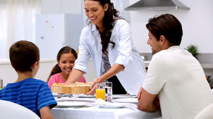 Mother bringing pizza to dinner table