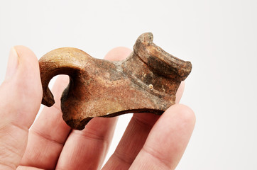 hand holds an potsherd