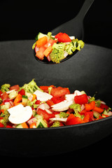 Vegetable ragout in wok, isolated on black