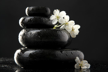 Obraz na płótnie Canvas Spa stones and white flowers isolated on black