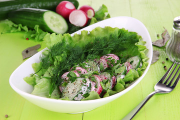 Vitamin vegetable salad in bowl on wooden table close-up