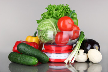 Fresh vegetables in scales on gray background