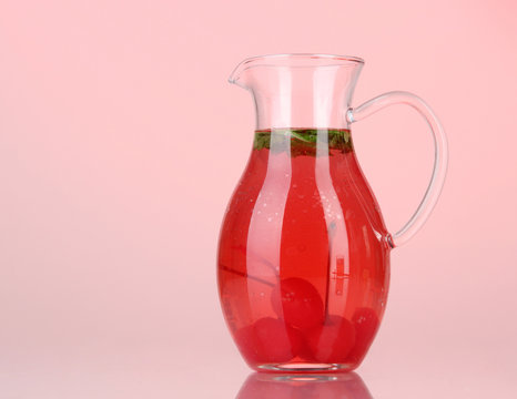 Cherry Drink In Pitcher On Red Background.