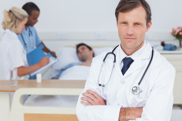 Fototapeta premium Serious doctor standing and looking at the camera