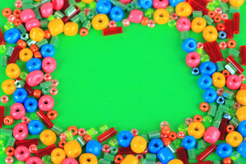 Different colorful beads on green background