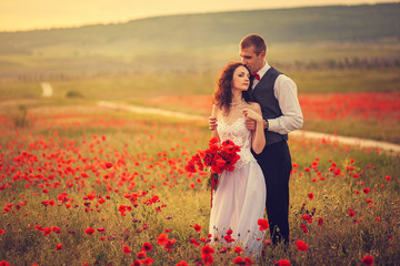 The bride and groom in a poppy field