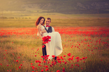 The bride and groom in a poppy field