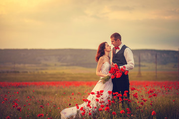 The bride and groom in a poppy field