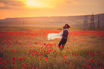 The bride and groom in a poppy field
