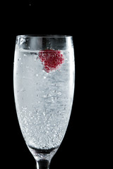 clear champagne with a raspberry