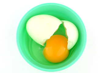 Cracked egg in cup on white background