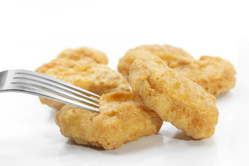 chicken nuggets food with fork on white