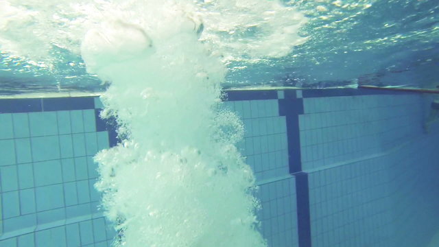 Junge springt in den Pool, Unterwasseraufnahme, Zeitlupe