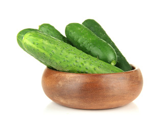 Tasty green cucumbers in wooden bowl, isolated on white