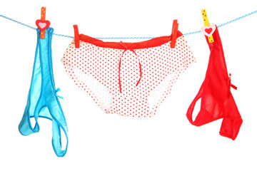 Women's panties hanging on rope isolated on white
