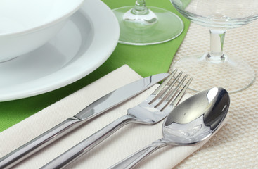 Table setting with fork, knife, spoon, plates, and napkin