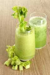 Glasses of celery juice on wooden background