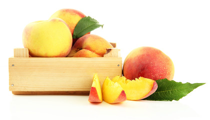 Ripe sweet peaches in wooden crate, isolated on white