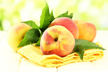 Ripe sweet peaches on wooden table in garden, close up
