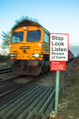 Beware of trains concept image with moving train in background