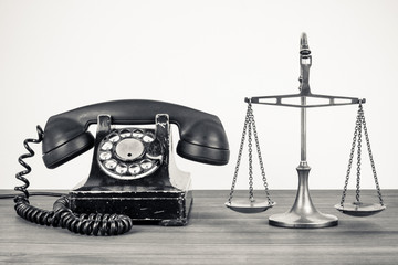 Retro old telephone and scales on wood table sepia photo