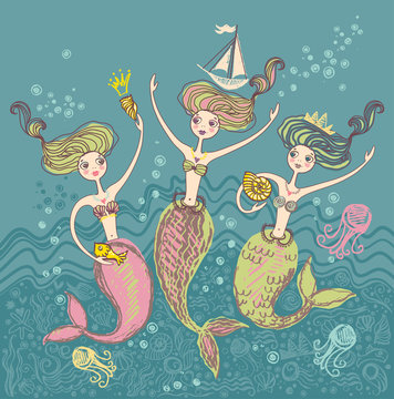Three little funny mermaids playing in the sea waves.