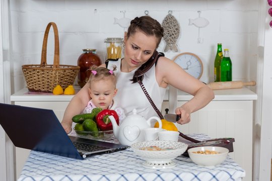 Mother with baby in kitchen.