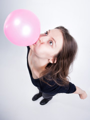 pretty girl making chewing gum balloons