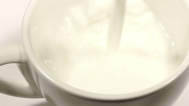 Milk flowing in a cup