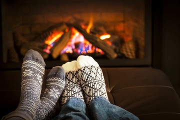 Feet warming by fireplace - obrazy, fototapety, plakaty
