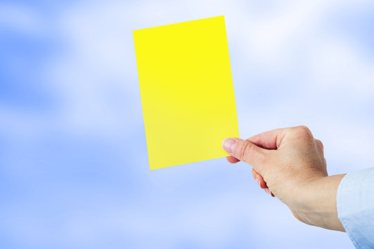 Hand shows a yellow card
