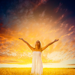 Fototapeta na wymiar woman walking on wheat field over sunset