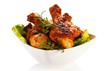 Grilled chicken legs and vegetables on white background