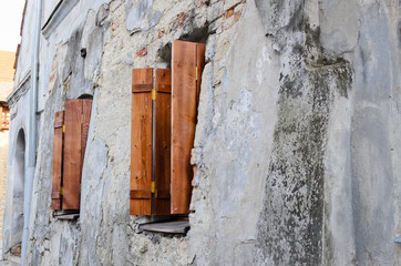 Two wooden windows on an old degraded wall