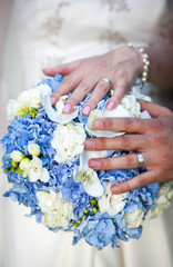 Fototapeta premium Hands and rings on wedding bouquet