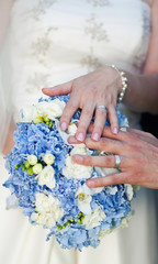 Fototapeta premium Hands and rings on wedding bouquet