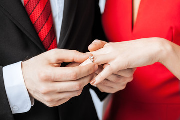 man putting  wedding ring on woman hand