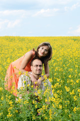 Happy man and woman in yellow meadow