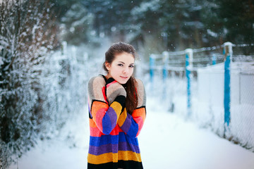 Young pretty girl standing in winter on the street