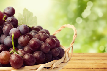 Grapes in basket over nature bokeh background with copy space