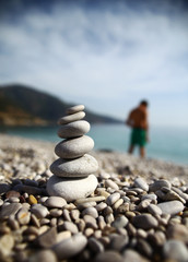 Stacked stones at the beach and a man