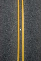 Fototapeta premium double yellow lines divider on blacktop