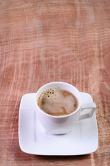 Coffee cup and hot water on a wooden table