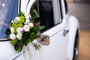Bouquet of flowers on bridal car's mirror